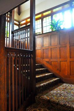 the stairs are made of wood and have decorative railings on each side, along with carpeted flooring