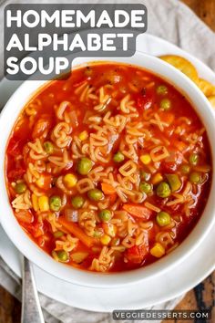 a bowl of homemade alphabet soup with peas and carrots