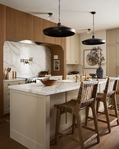 a kitchen with marble counter tops and wooden stools