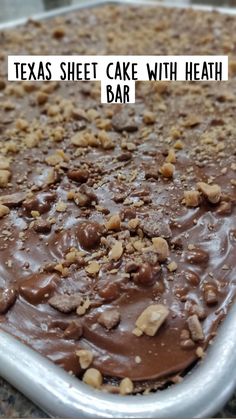 a close up of a cake with chocolate frosting and nuts on top in a pan