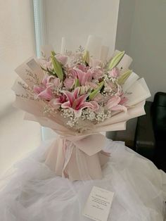 a bouquet of pink flowers sitting on top of a white table next to a mirror