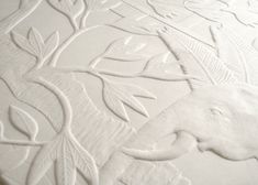 an elephant is depicted on the surface of a bed sheet that's made out of white embossed paper