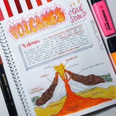 a notebook with an image of volcanos on it and some markers next to it