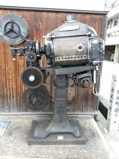 an old fashioned machine is on display in front of a wooden wall