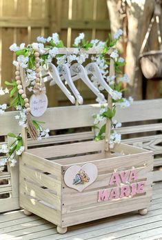 a wooden crate sitting on top of a wooden table next to flowers and other decorations