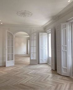 an empty room with white doors and wooden floors