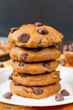 a stack of chocolate chip cookies sitting on top of a white plate