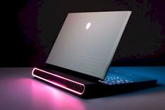 an illuminated laptop computer sitting on top of a table