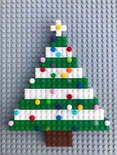 a christmas tree made out of legos on top of a gray surface with colorful beads