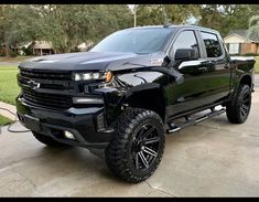 a black truck parked on top of a driveway