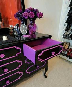 a black and purple dresser with flowers on it