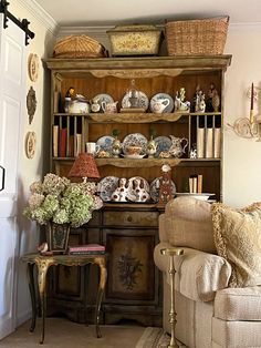 a living room filled with furniture next to a wall covered in plates and vases