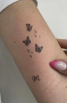 a woman's arm with butterflies on it and the word mom written in cursive writing