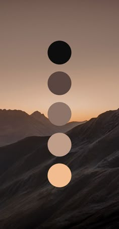 the sun is setting over some mountains with circles on it's face and in between them, there are three different colors