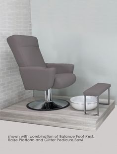 a modern recliner chair and foot rest in front of a brick wall