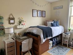 a bed room with a neatly made bed next to a desk and chair near a window