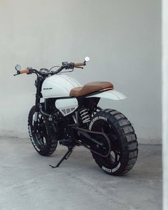 a white motorcycle parked next to a wall