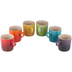 a set of six multicolored coffee mugs sitting next to each other on a white background