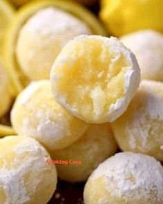 a pile of powdered sugar balls sitting next to lemons