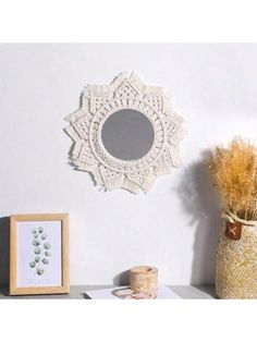 a white doily hanging on the wall next to a vase with dried grass in it