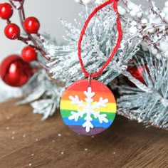 a wooden ornament with a snowflake on it hanging from a christmas tree