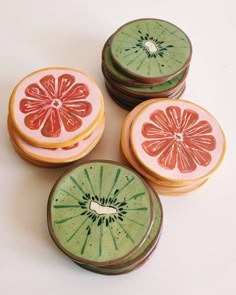 four pieces of fruit are sitting on the table together, including one slice of grapefruit