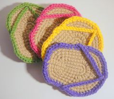 four crocheted coasters sitting on top of a table