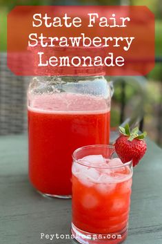 two glasses filled with strawberry lemonade sitting on top of a table