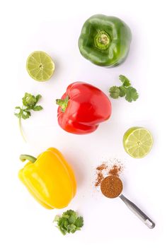 peppers, limes and spices on a white surface