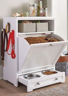 a white cabinet with drawers and two bowls in it next to a rug on the floor