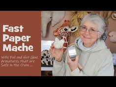 an older woman holding up a fake giraffe and another animal in the background