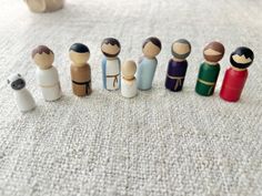 a group of small wooden dolls sitting on top of a white carpet