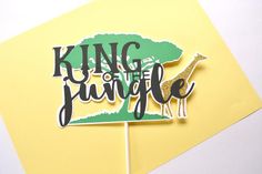 a cake topper that says king of the jungle with a giraffe on it