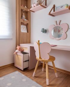 a child's room with pink furniture and accessories on the shelves, along with a white rug