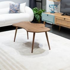 a living room with two white couches and a coffee table in front of a tv