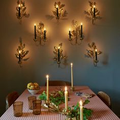 a dining room table with candles on the wall