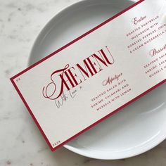 a white plate topped with a red and white menu