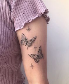 a woman's arm with two butterflies tattoo on the left side of her arm