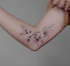 a woman's arm with flowers on it