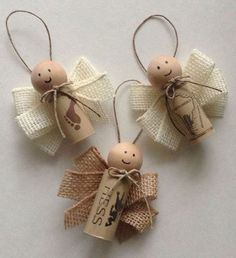 two wooden angel ornaments with tags attached to them