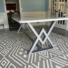 a dining room table in the middle of a living room with an area rug on the floor