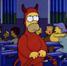 a cartoon character in a red devil costume standing next to other people at a table