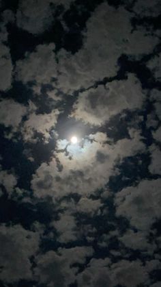 the moon is shining brightly in the cloudy sky