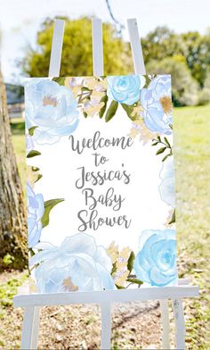 a welcome sign for a baby shower with blue flowers and the words welcome to jesus's baby shower on it