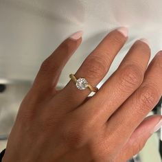 a woman's hand with a diamond ring on it