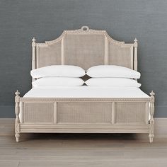 a bed with white linens and pillows on top of it in a gray room