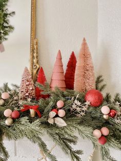 a mantel decorated with christmas trees and ornaments