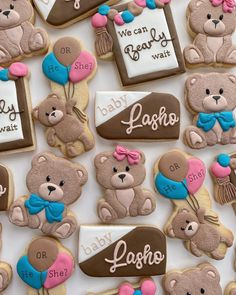 cookies decorated with teddy bears and name tags are displayed on a white tablecloth that says baby, bear, i love you