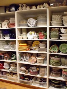 the shelves are filled with dishes and plates