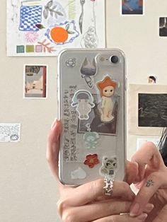 a woman holding up her phone case with stickers on it